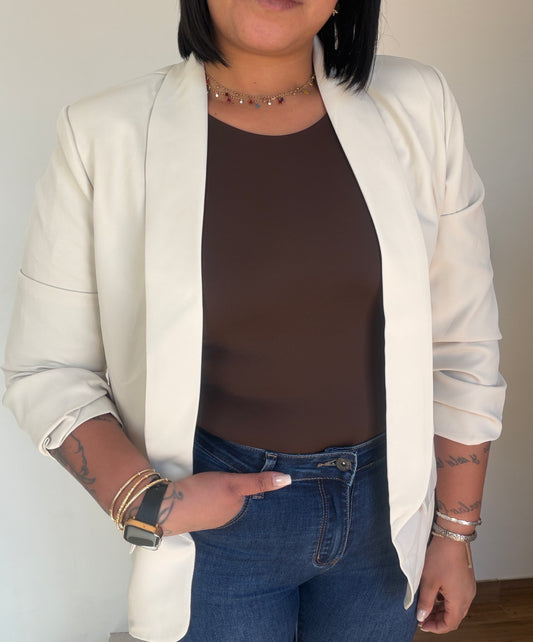 Blazer abierta blanca combinada con body marrón y jeans talle alto