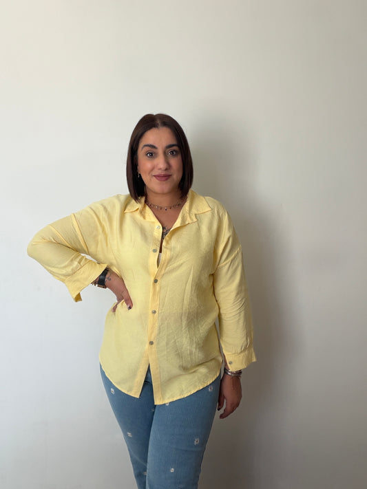 Outfit primavera camisa amarilla anudada a la cintura con jeans.