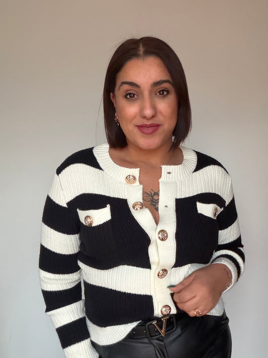 Primer plano de botones metálicos dorados en cárdigan marinero