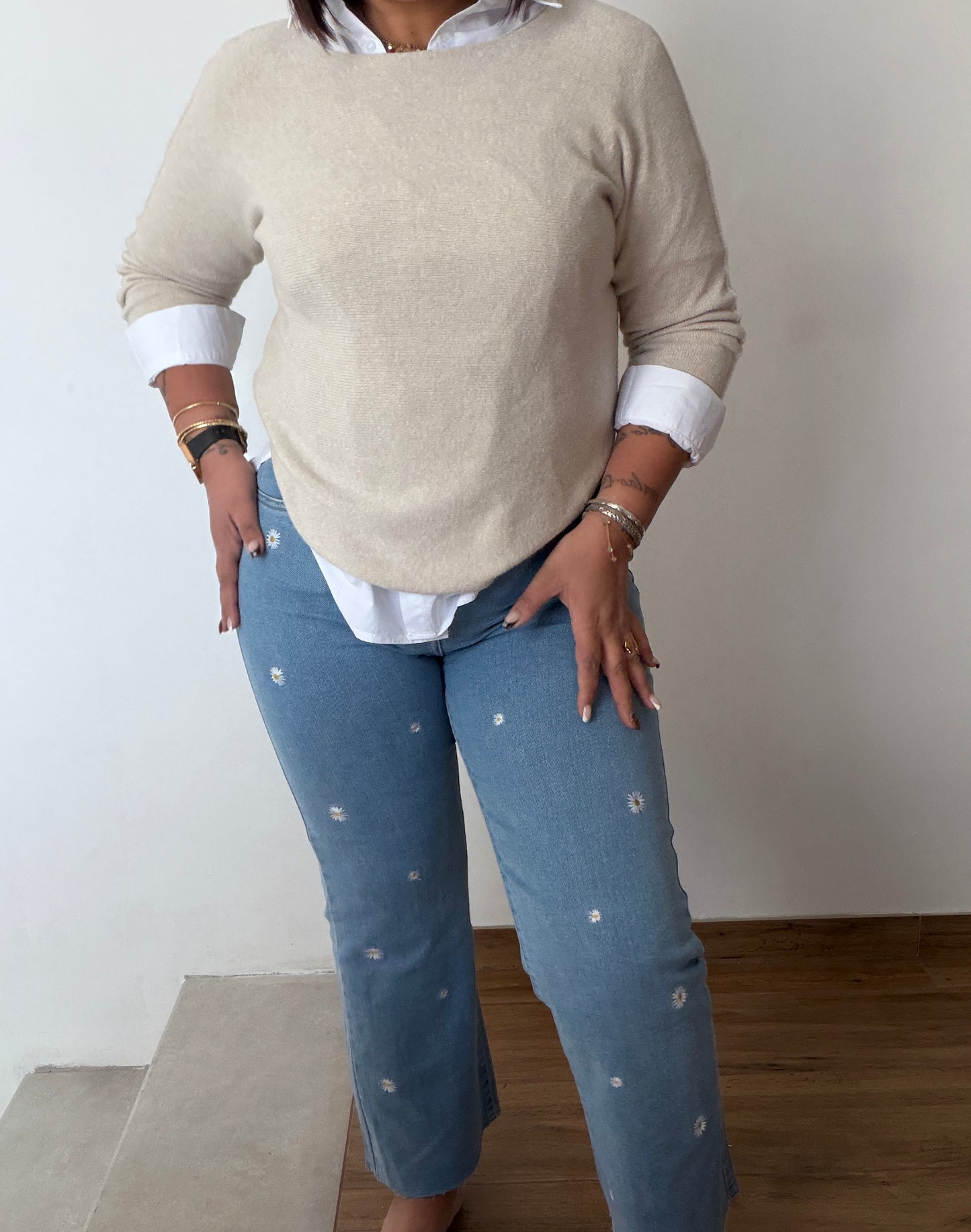 Outfit mujer con vaqueros bordados margaritas y camisa blanca.