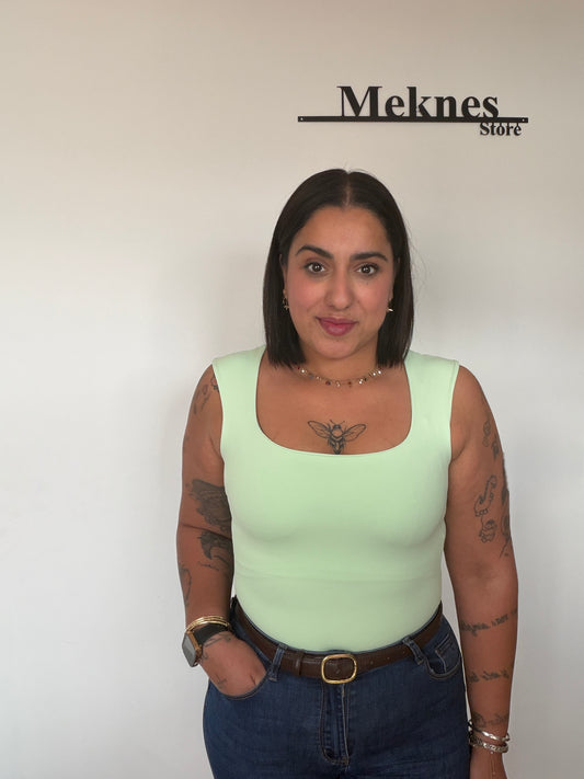 Modelo con body verde pastel moldeador combinado con vaqueros de tiro alto