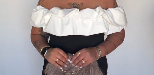 Outfit elegante de evento con vestido negro ajustado y escote blanco palabra de honor