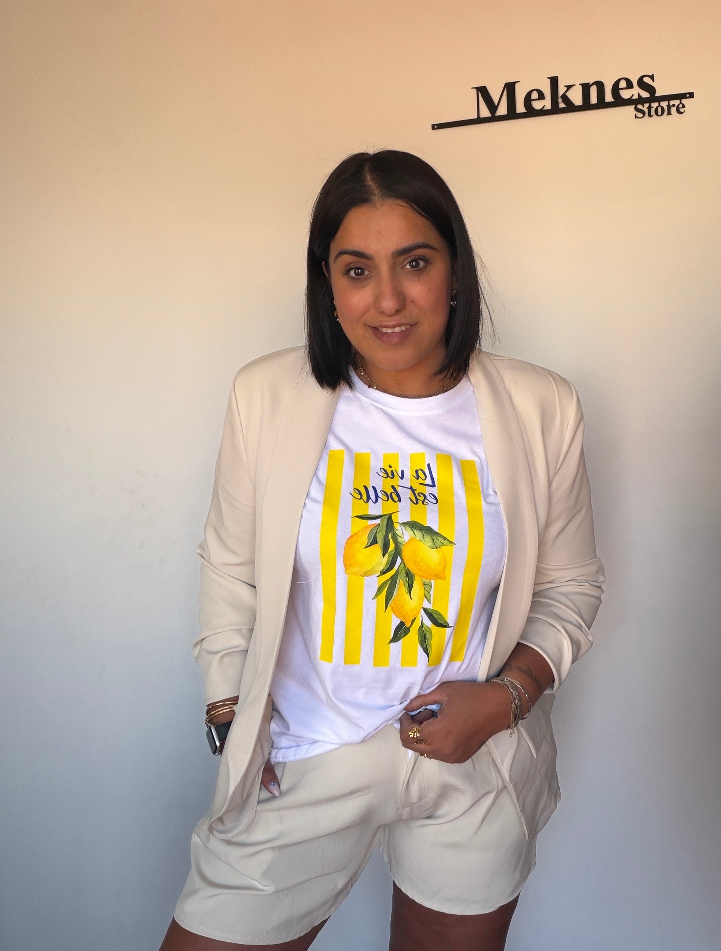 Mujer luciendo bermuda de vuelo beige de tiro alto combinada con americana a juego Meknes Store