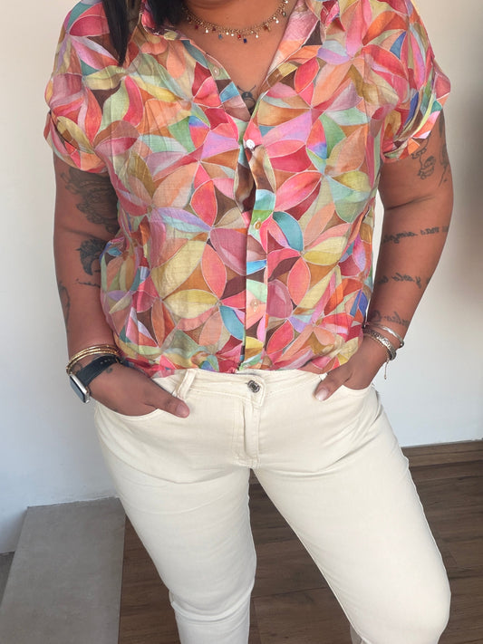 Blusa fluida estampada tonos cálidos combinada con pantalón blanco