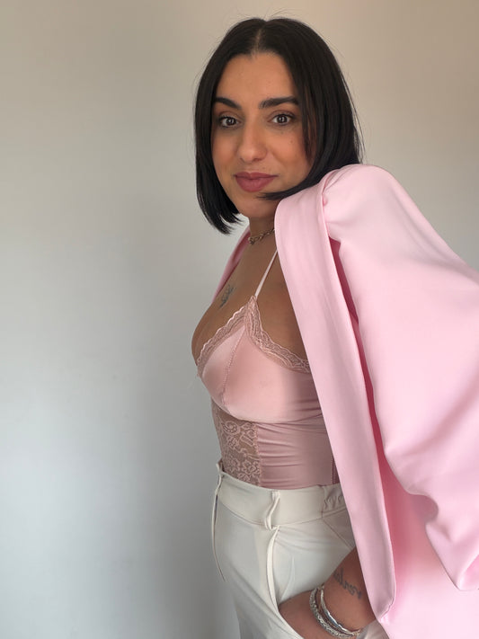 Vista lateral body satinado rosa ajuste perfecto silueta.