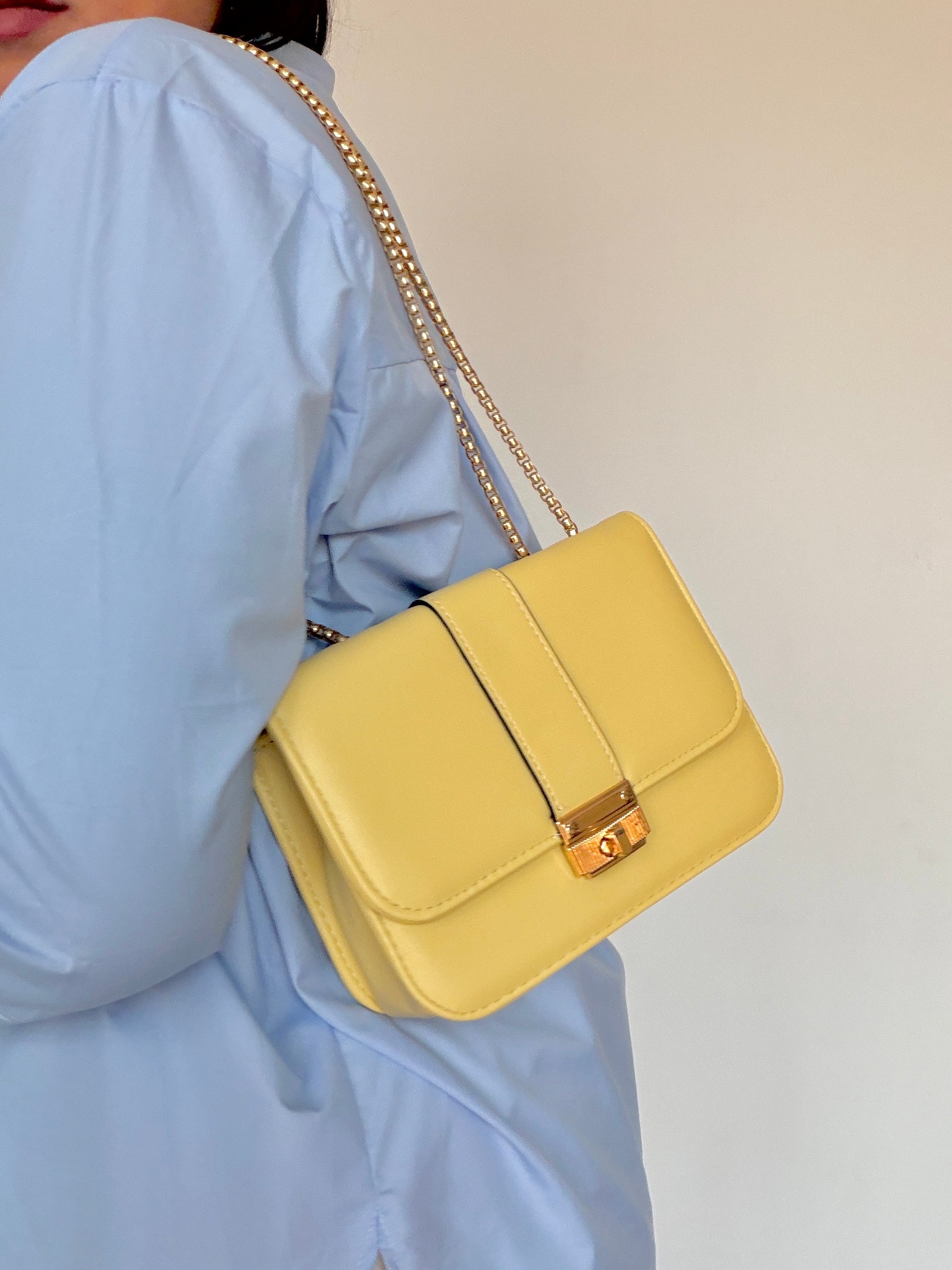 Bolso amarillo pastel llevado al hombro con cadena de eslabones dorados Meknes