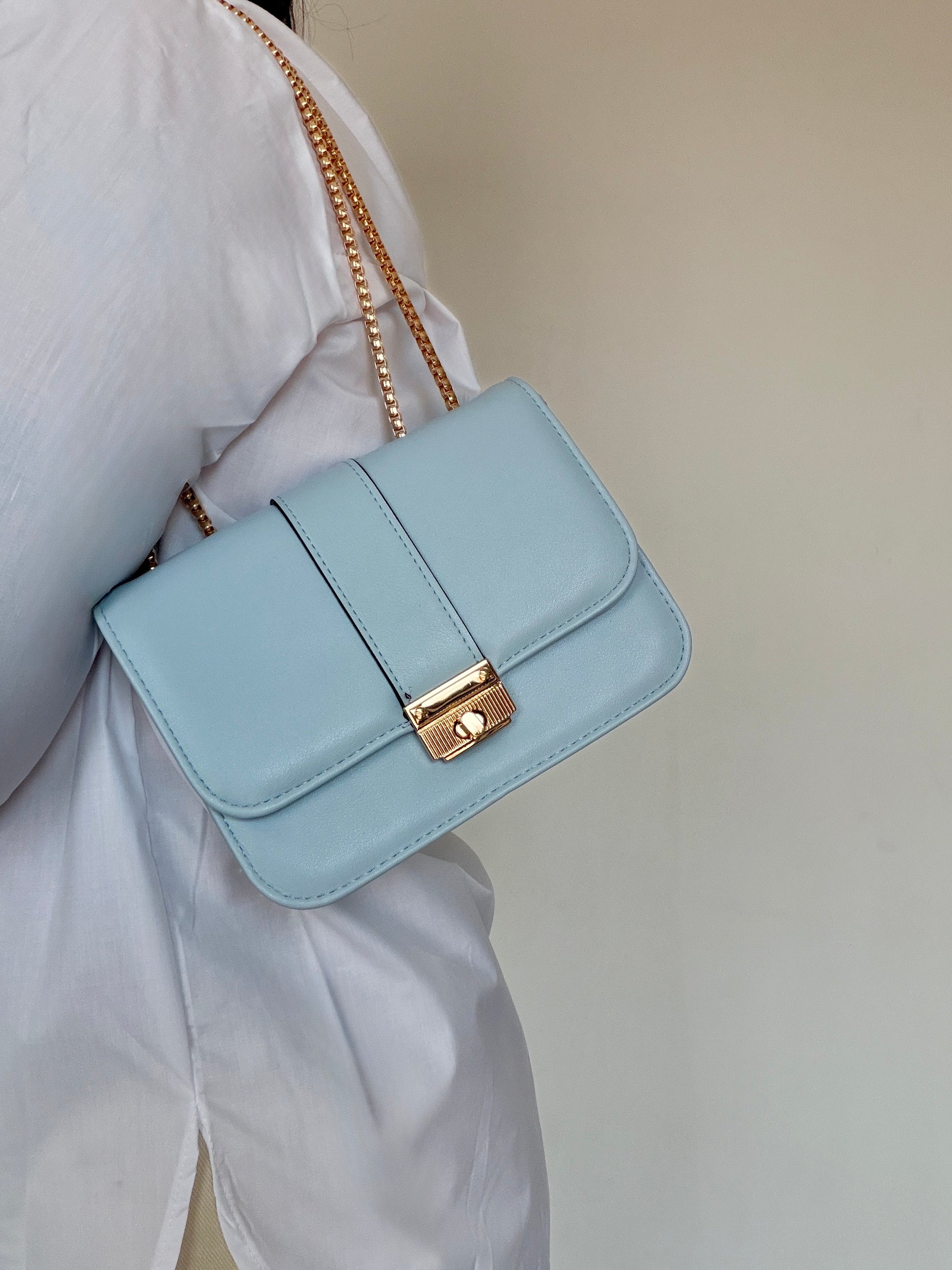 Detalle de bolso azul baby al hombro con acabado elegante y cierre dorado Meknes