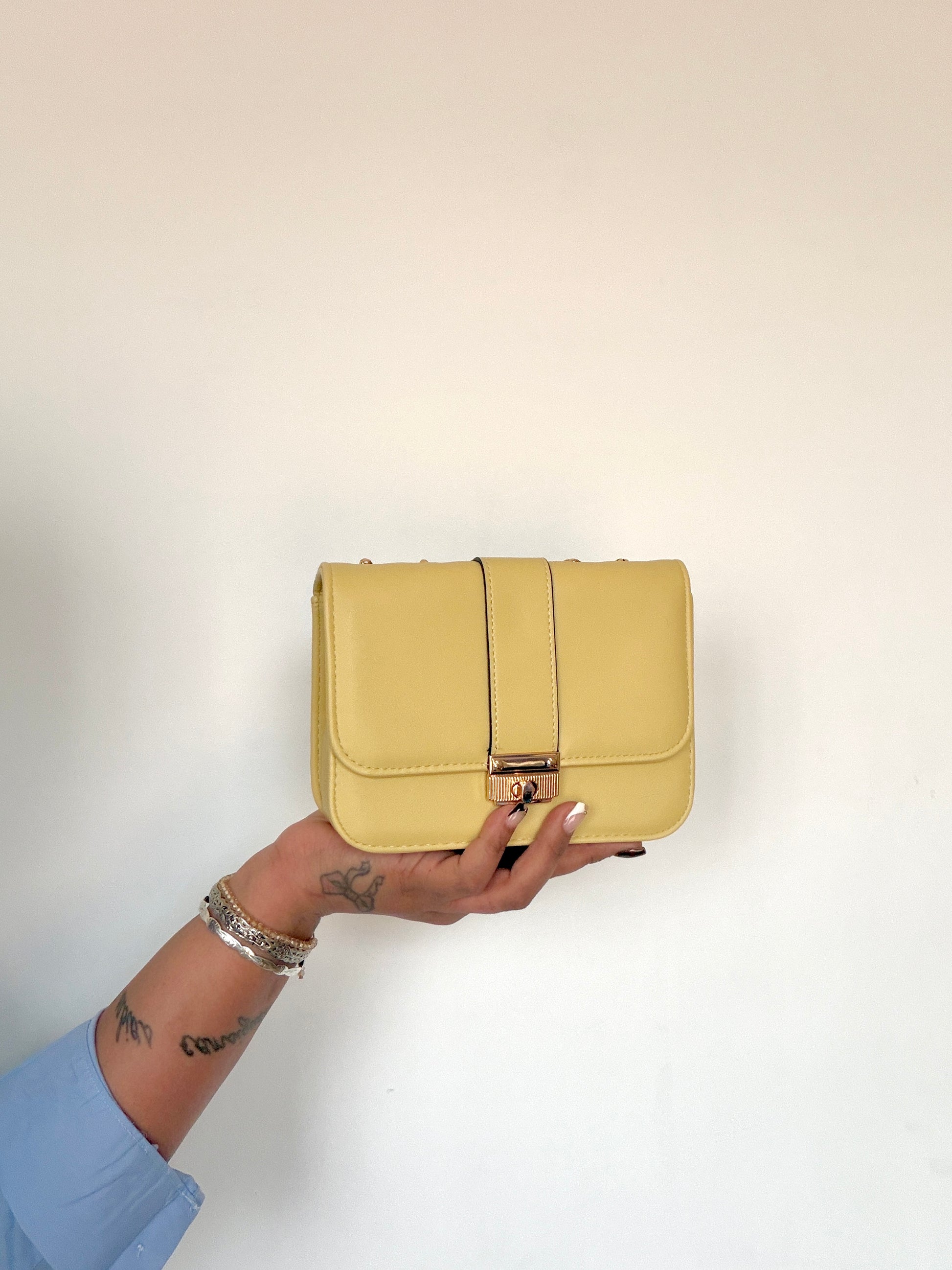 Primer plano de bolso pequeño amarillo solar mostrado en la mano Meknes
