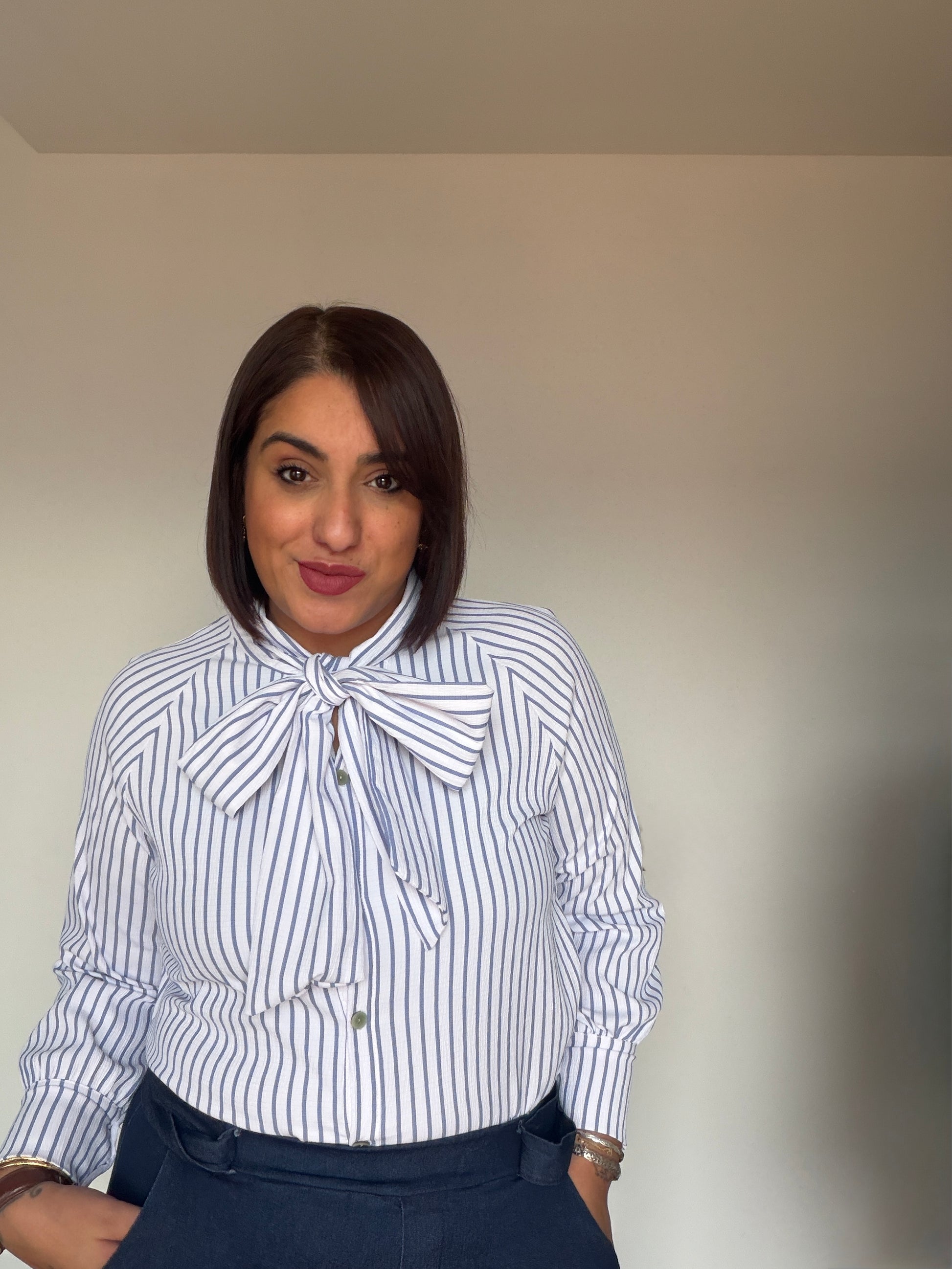 Camisa fluida rayas azul y blanco suave con lazo ajustable al cuello.