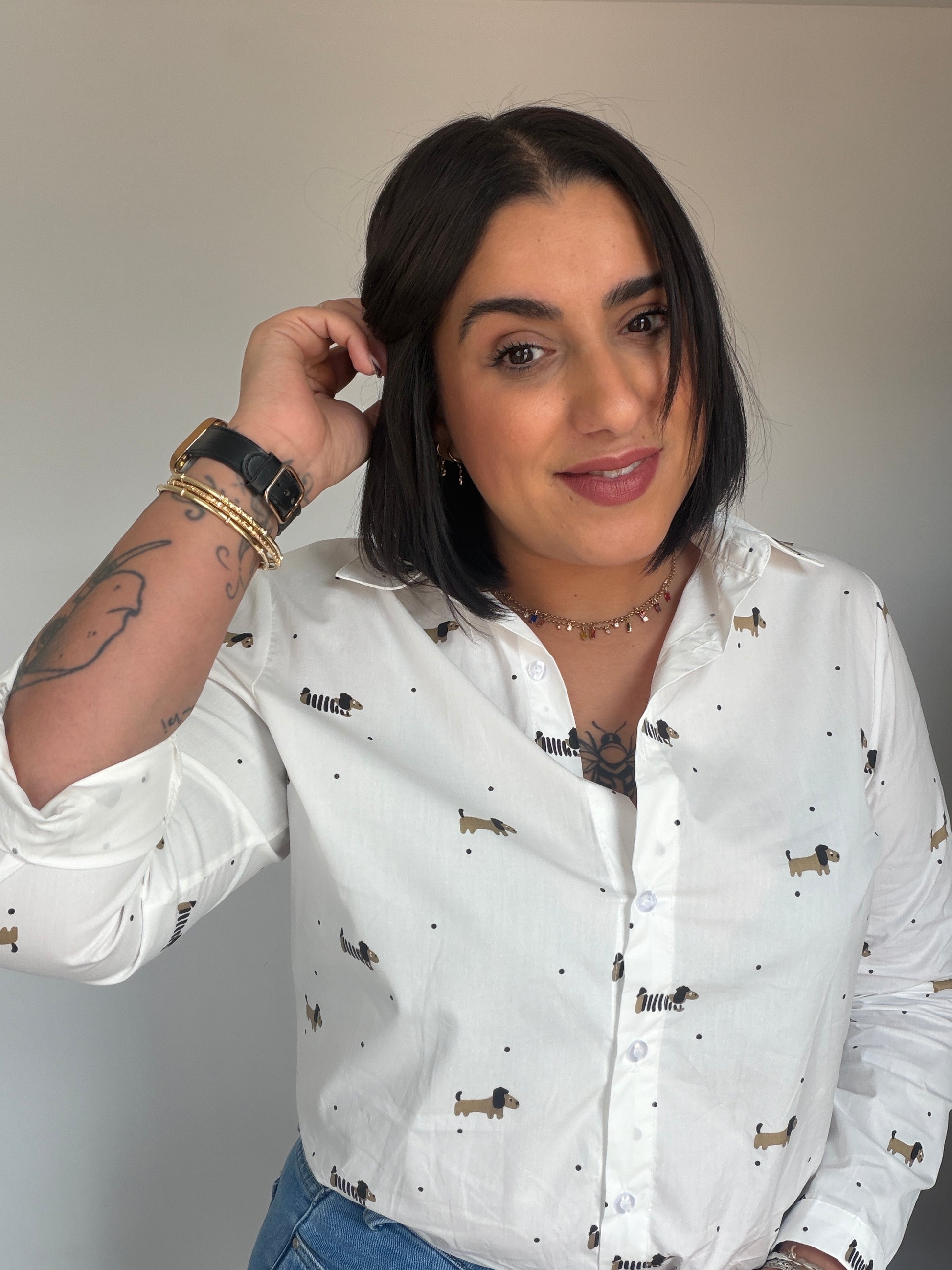 Mujer vistiendo camisa blanca 100% algodón con estampado de perros teckel y lunares negros.