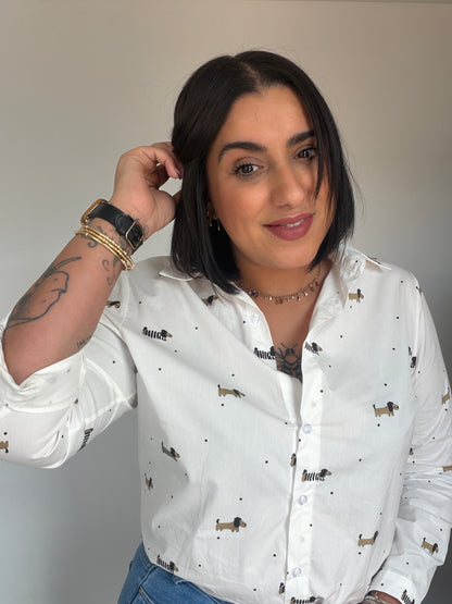 Mujer vistiendo camisa blanca 100% algodón con estampado de perros teckel y lunares negros.