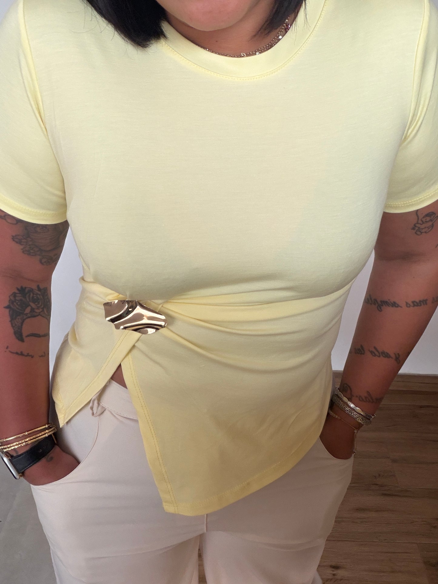 Camiseta amarillo claro con detalle metálico dorado en la cintura