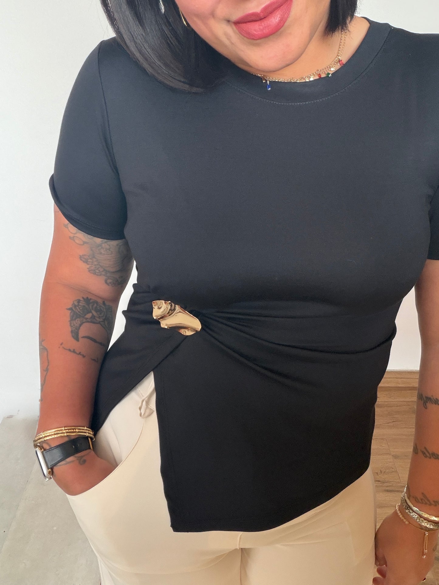 Camiseta negra asimétrica con fruncido y broche joya dorado Meknes Store