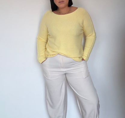 Look con pantalón negro balloon y body beige con detalle de abertura en el pecho.