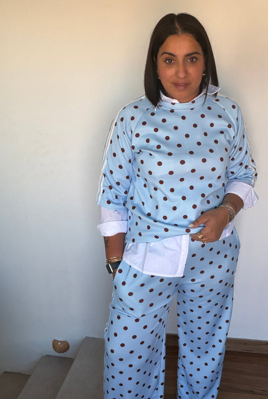 Mujer luciendo conjunto deportivo oversize azul celeste con lunares y camisa blanca debajo Meknes Store