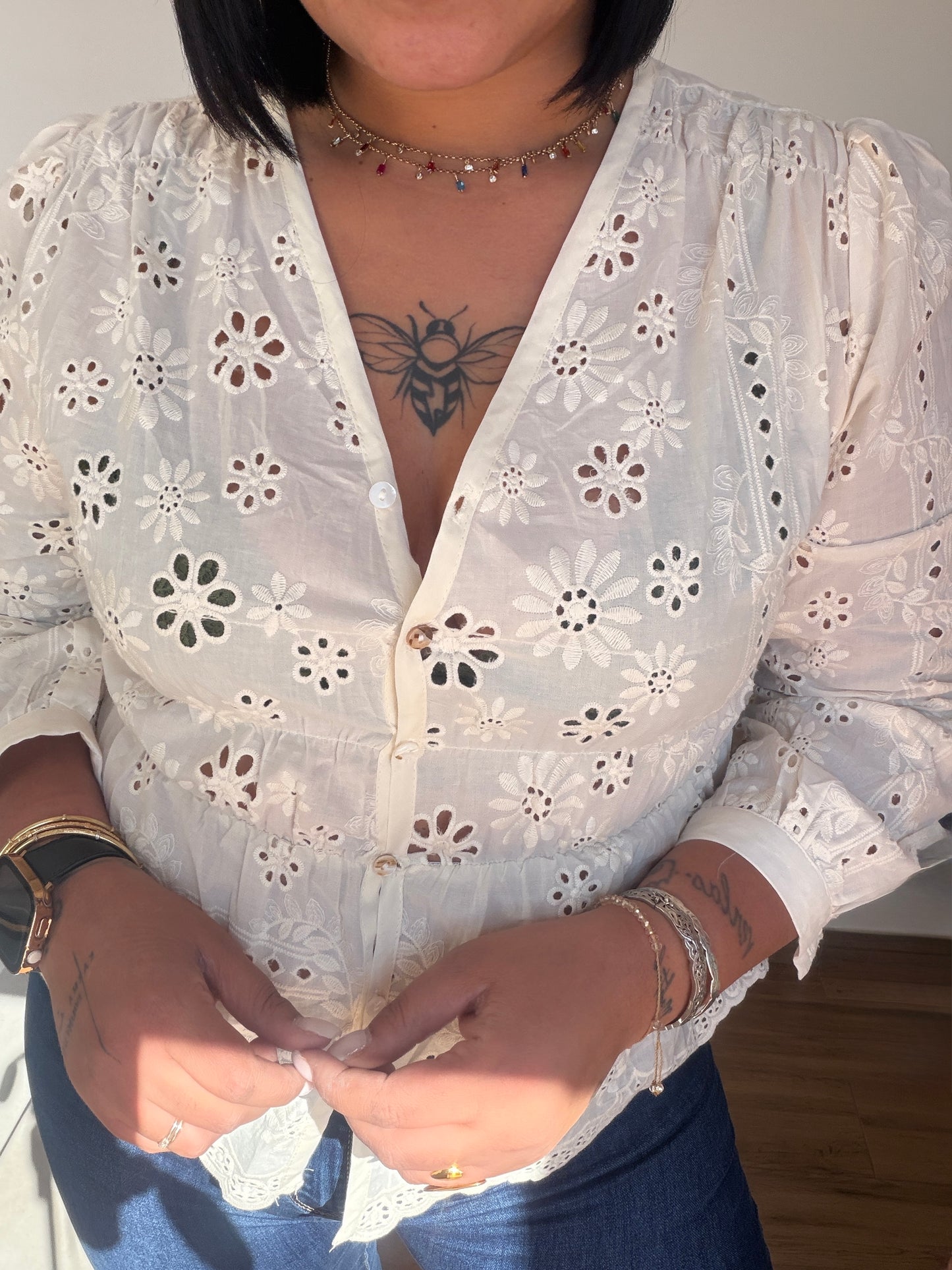 Primer plano de los botones y el tejido bordado calado de la blusa París