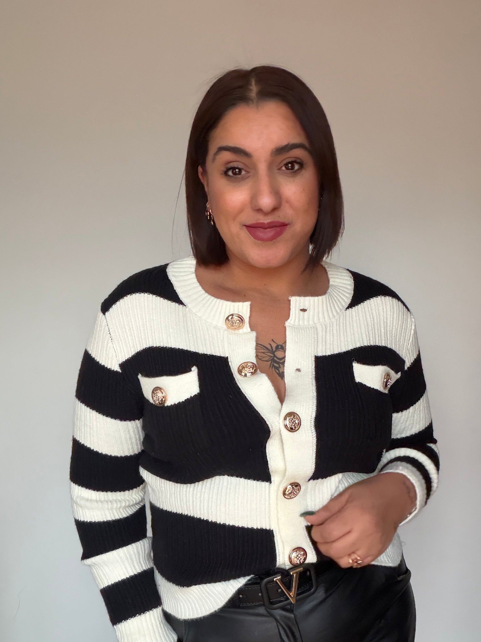 Primer plano de botones metálicos dorados en cárdigan marinero