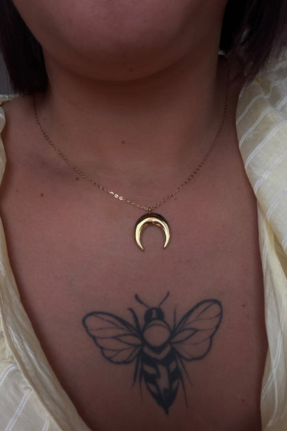 Detalle de colgante media luna dorada resistente al agua