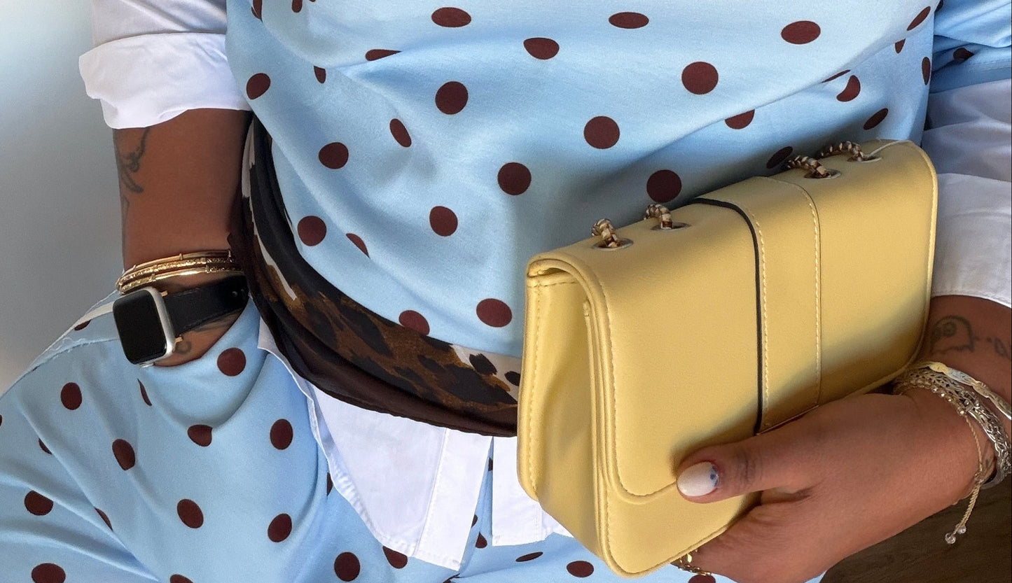 Detalle de contraste de color entre bolso mostaza y conjunto deportivo azul claro