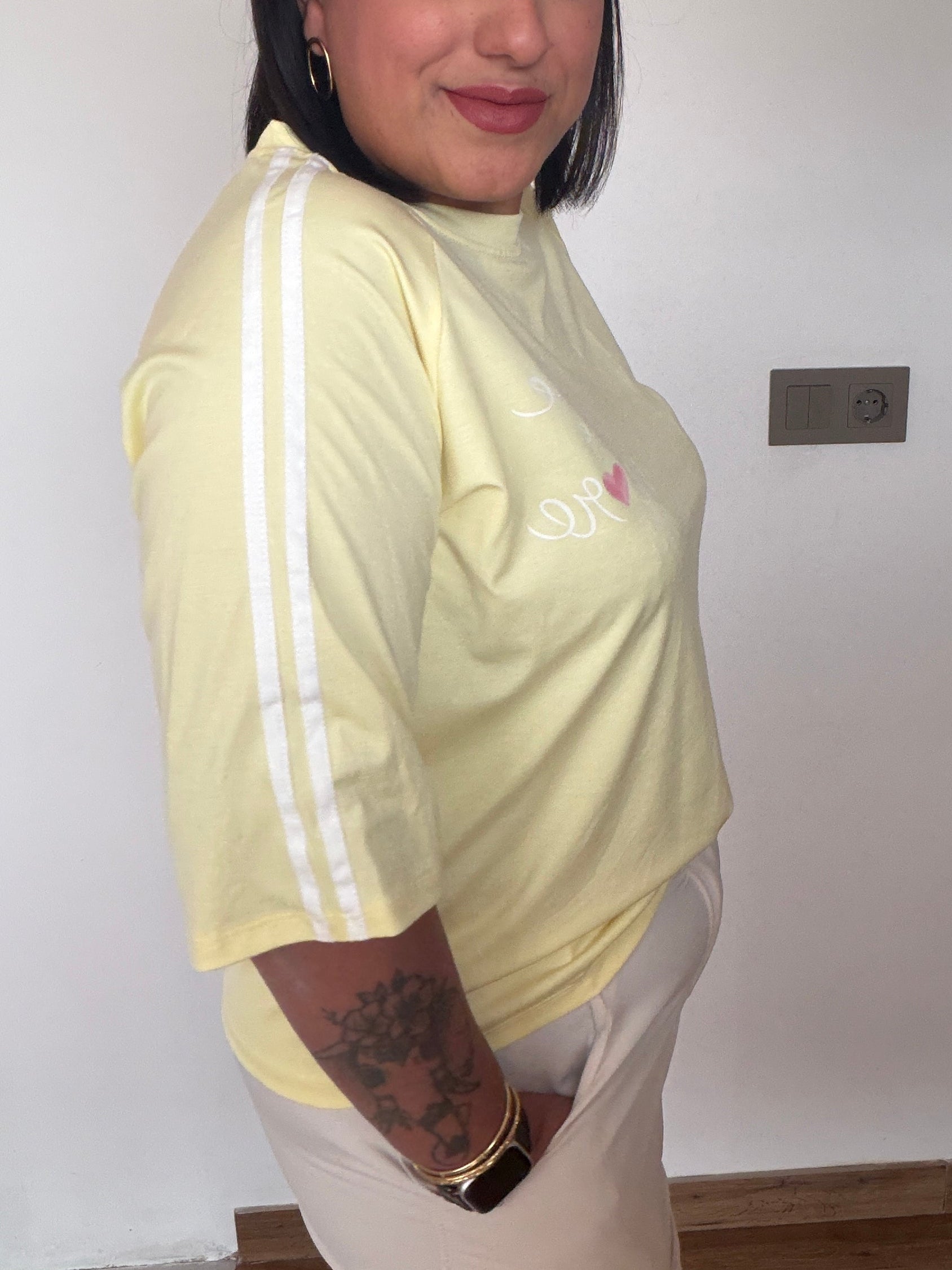 Vista lateral mostrando el detalle de la doble franja blanca deportiva en la manga