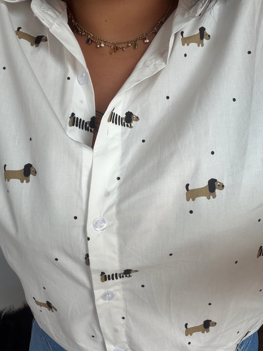 Primer plano de tejido 100% algodón con estampado de perro salchicha teckel y botones blancos.