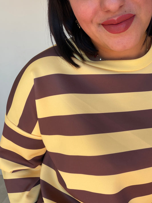 Detalle del acabado de rayas marrones y crema en sudadera premium