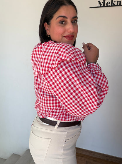 Primer plano del cierre con lazos rojos y detalle de volantes en blusa cherry vibes