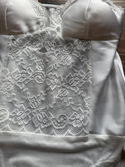 Detalle copa y escote body blanco satinado ajuste pecho.