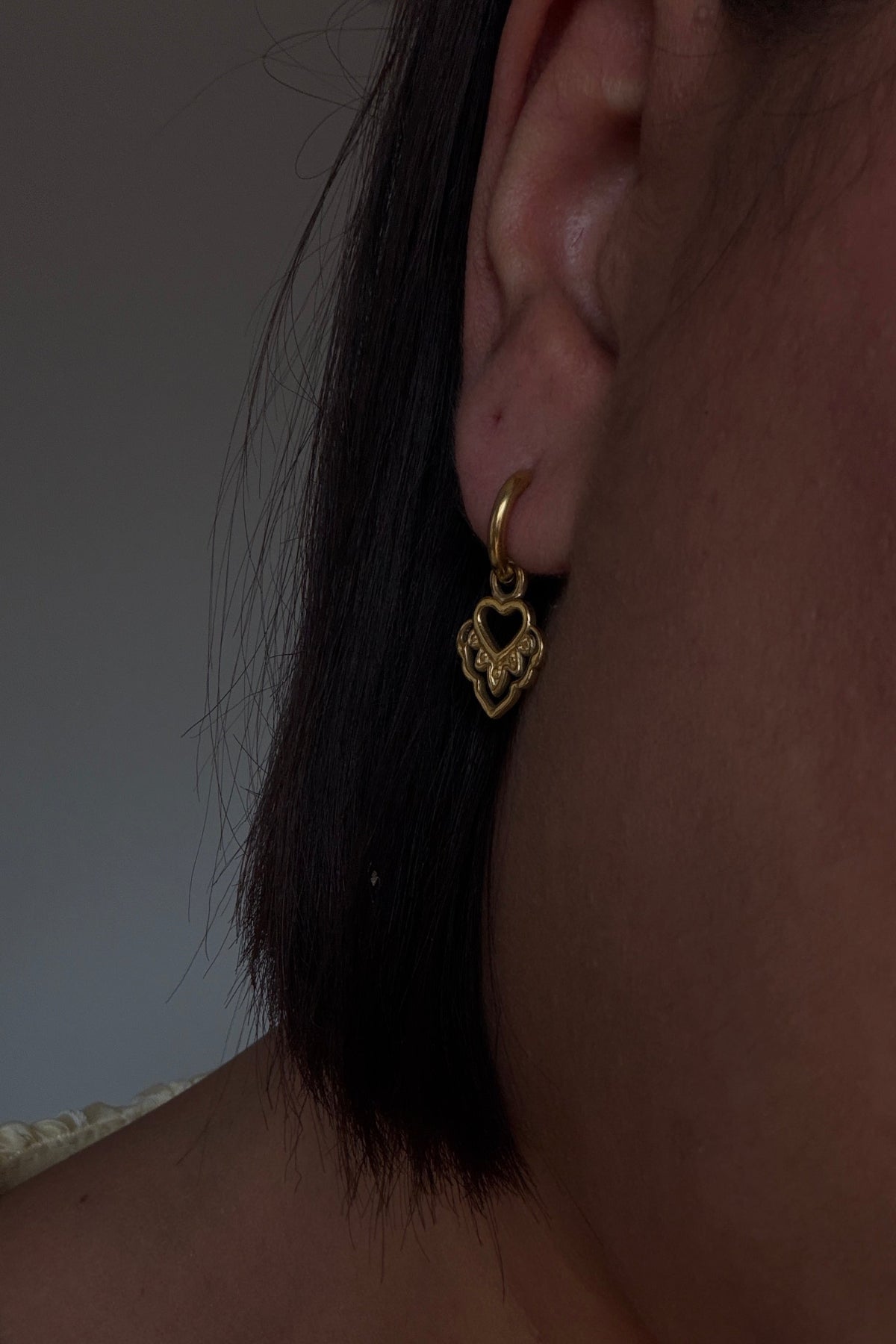 Primer plano de aros con charms de corazón joyería resistente al agua