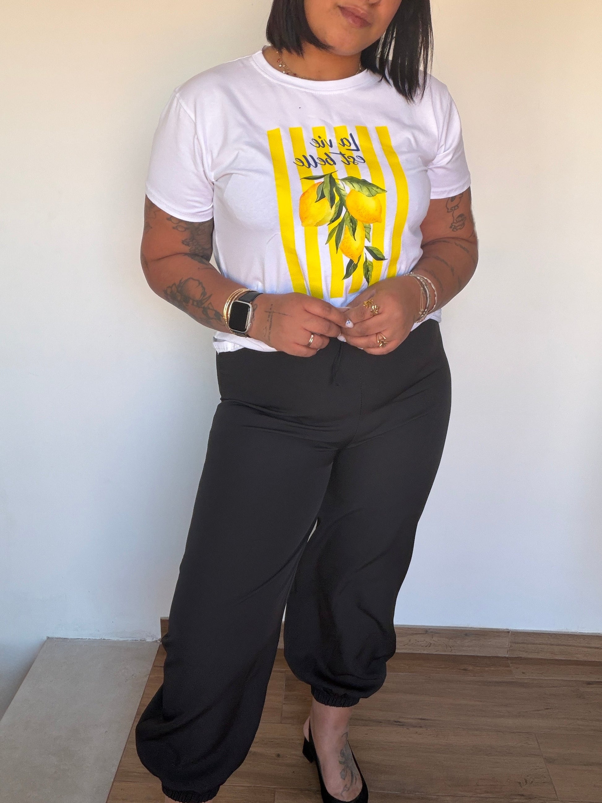 Vista lateral de pantalón negro elegante mostrando la caída y el ajuste en el tobillo