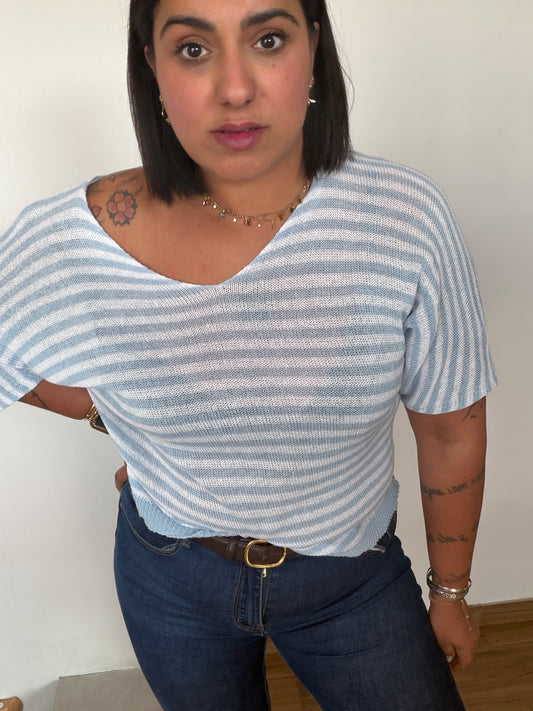 Camiseta casual de punto semitransparente con rayas azules sobre vaqueros