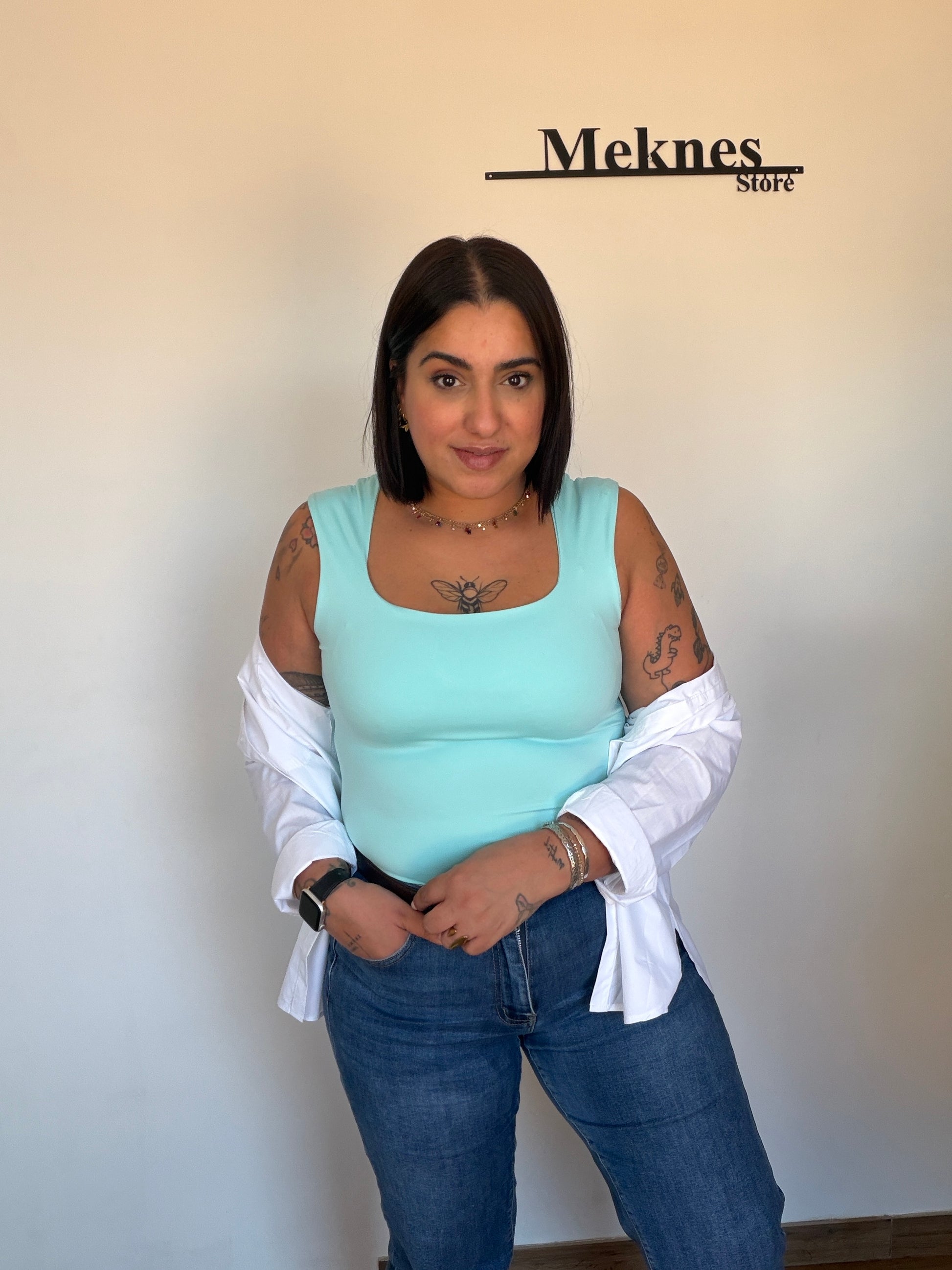 Outfit casual con camiseta nadadora turquesa y pantalones vaqueros azules