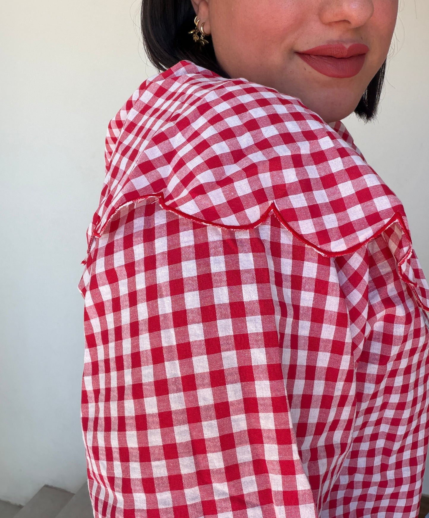 Outfit de primavera con blusa vichy roja y vaqueros azules de tiro alto