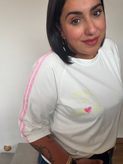 Modelo luciendo camiseta blanca con detalles retro sport en color rosa