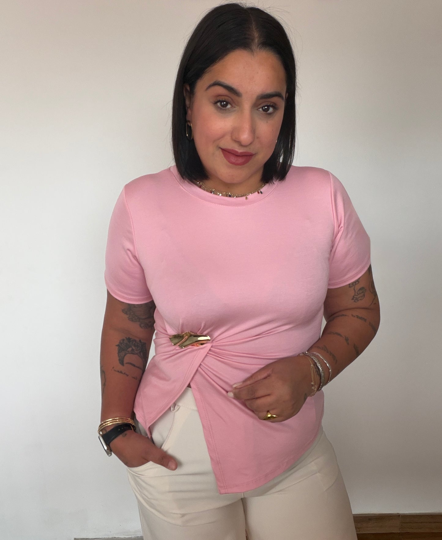 Look casual chic con camiseta rosa pastel detalle dorado y pantalón claro