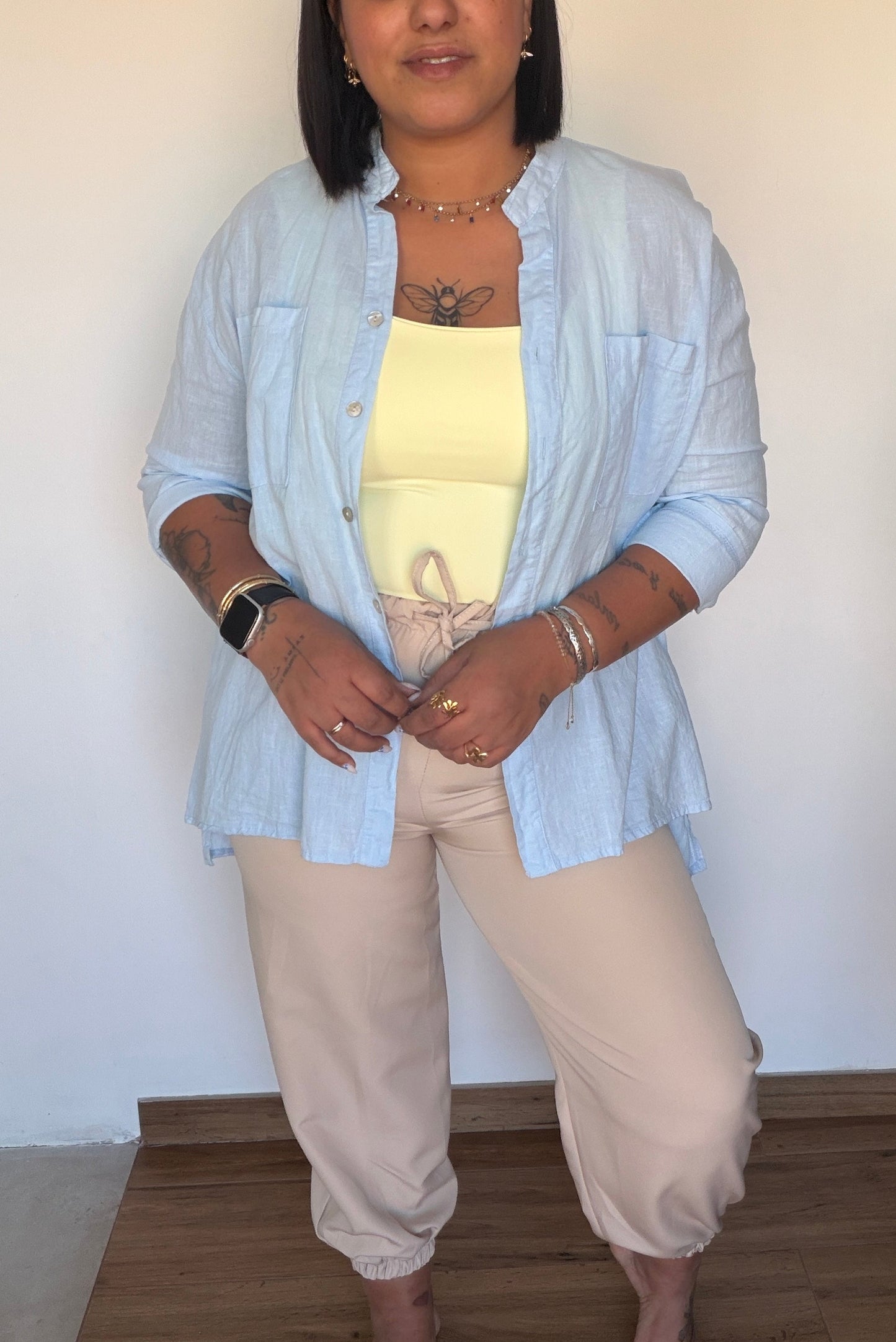 Pantalón capri beige estructurado combinado con sobrecamisa de lino azul claro