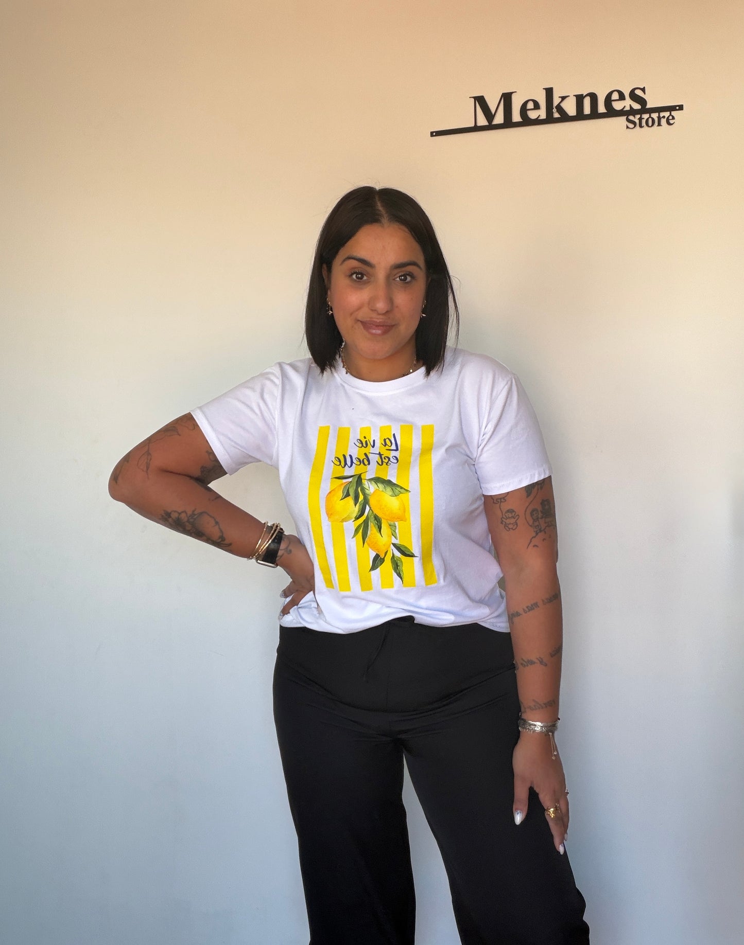 Pantalón capri negro de vestir con puño en el tobillo combinado con camiseta gráfica Meknes Store