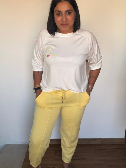 Mujer luciendo pantalón amarillo cómodo de cintura elástica con bolsillos laterales y cordón