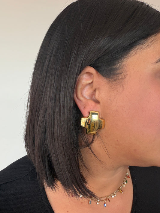 Primer plano de mujer con pendientes dorados pulidos en forma de cruz geométrica Meknes Store