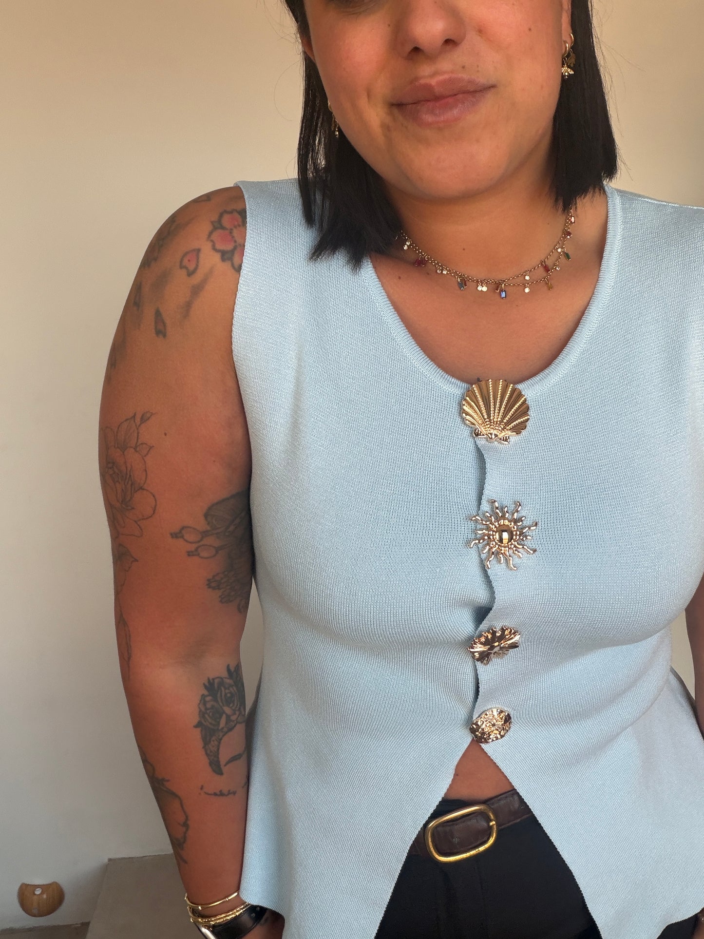 Top azul claro sin mangas con botones dorados marineros en contraste