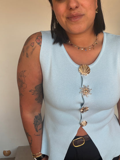 Top azul claro sin mangas con botones dorados marineros en contraste