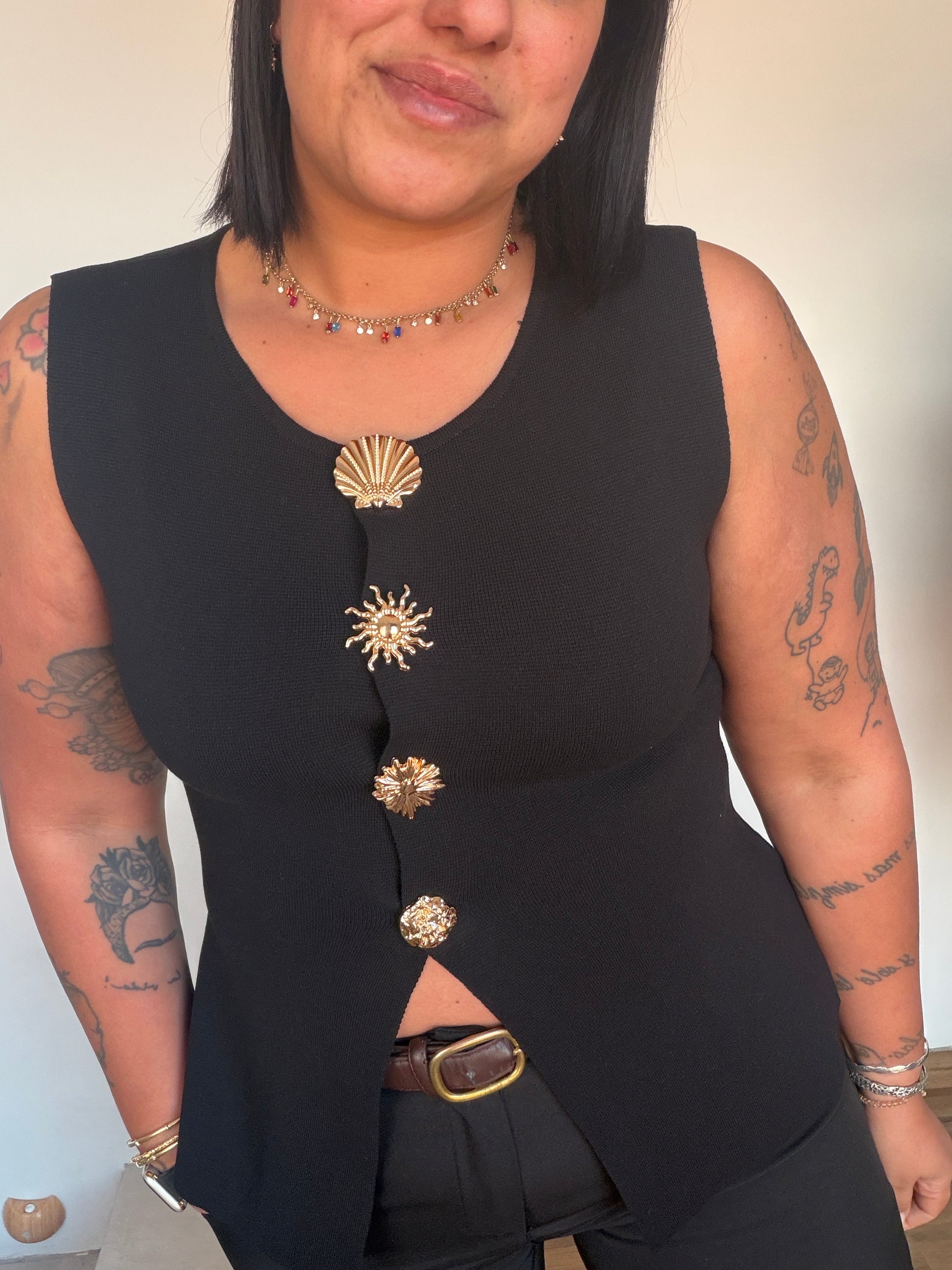 Top negro básico elegante con botones dorados y abertura frontal