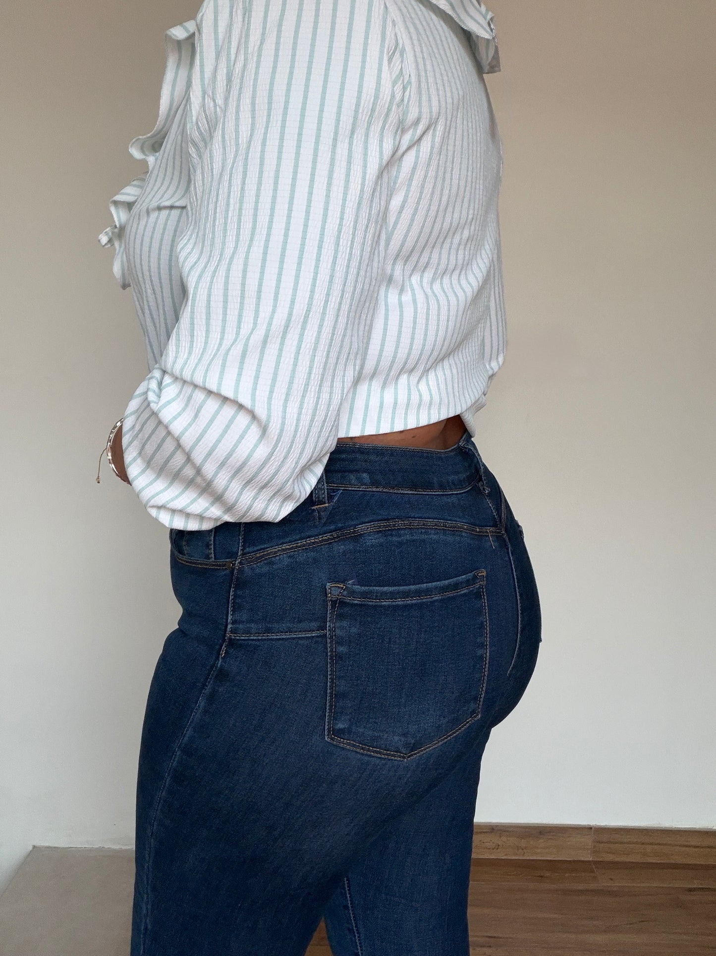 Vista lateral del denim slim azul marino mostrando la caída y el tejido elástico