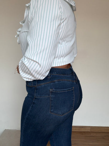 Vista lateral del denim slim azul marino mostrando la caída y el tejido elástico