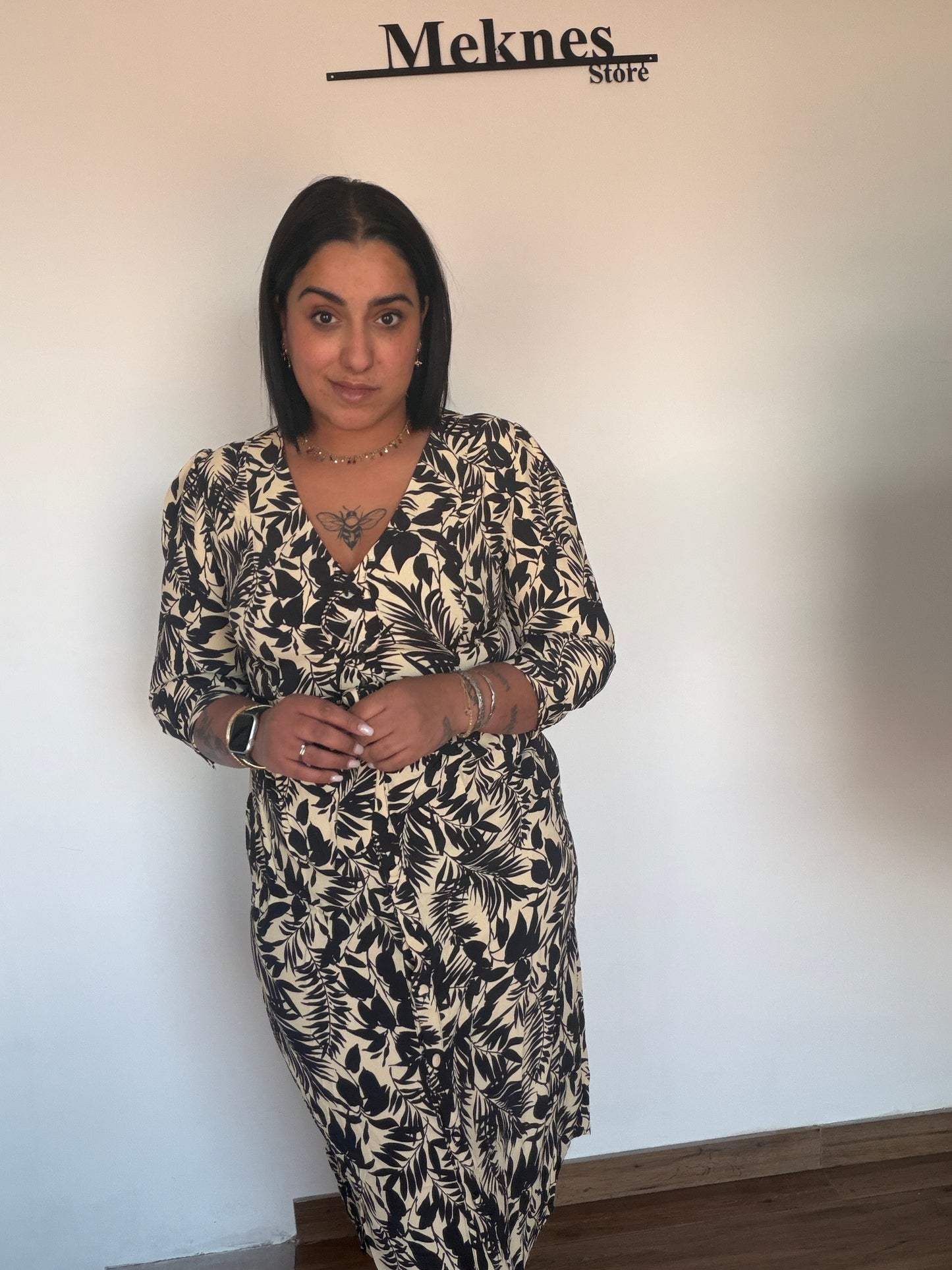 Vestido de primavera elegante estampado de hojas negras sobre fondo beige