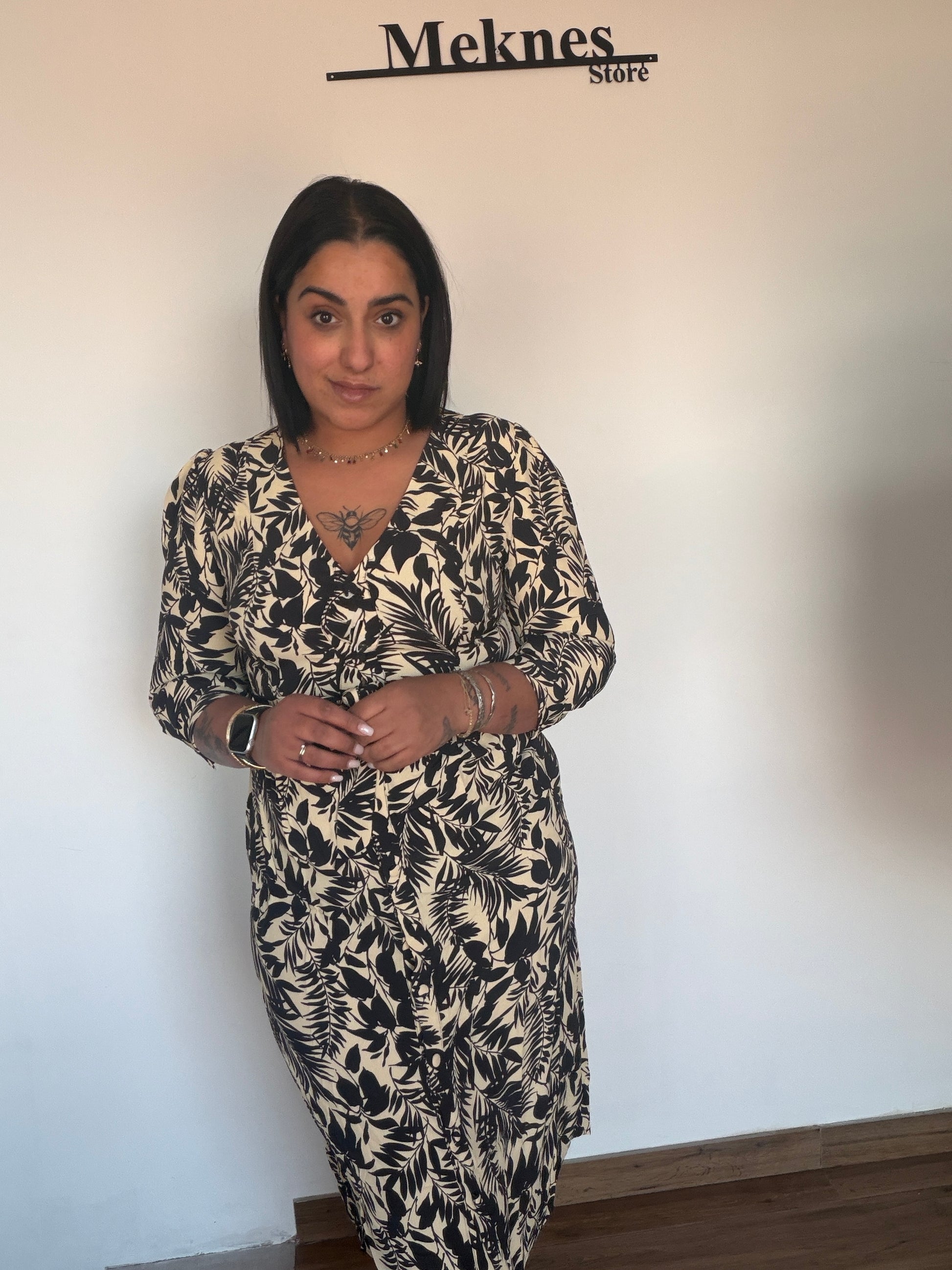 Vestido de primavera elegante estampado de hojas negras sobre fondo beige