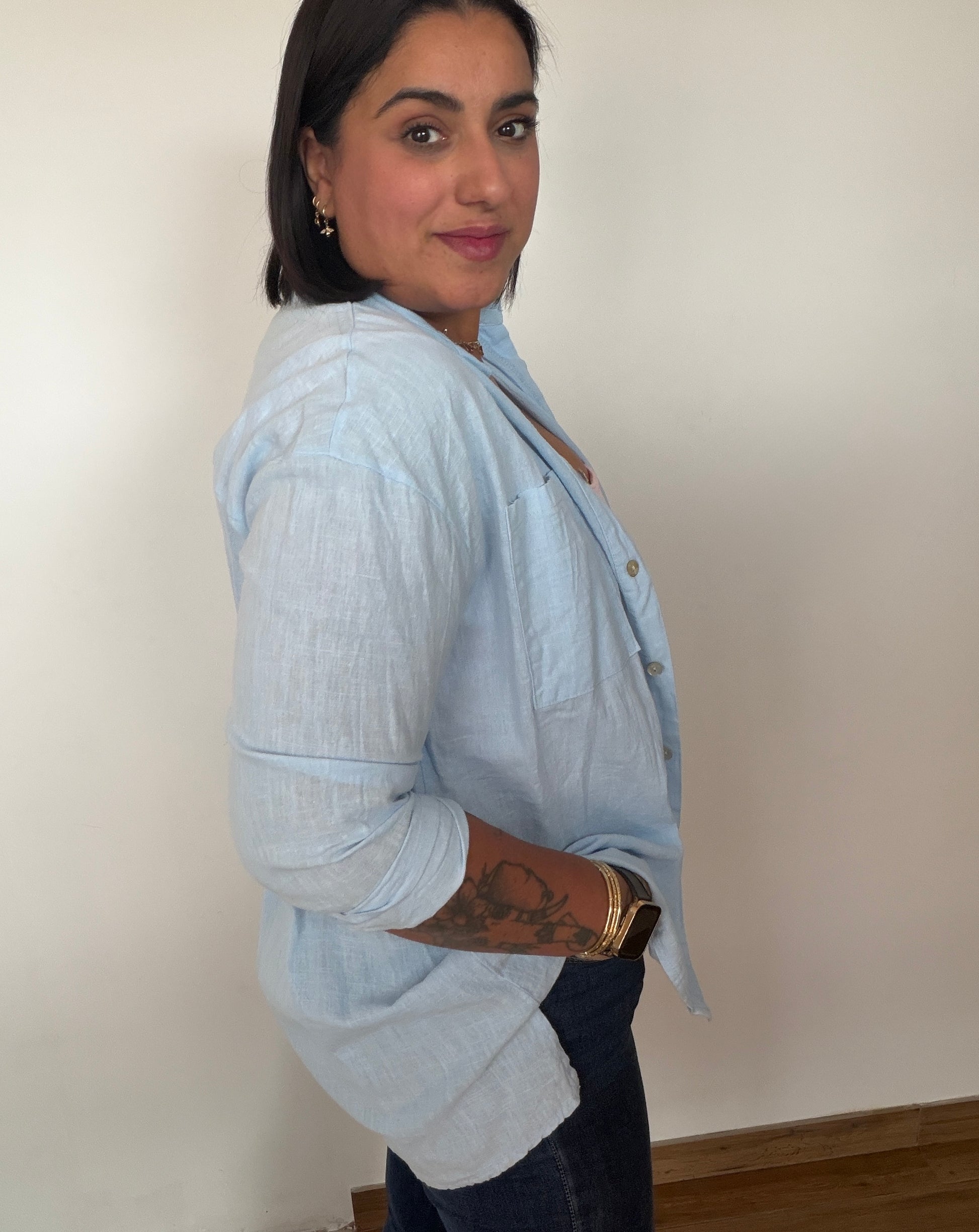 Vista lateral de camisa de lino oversize mostrando la caída y el largo del tejido