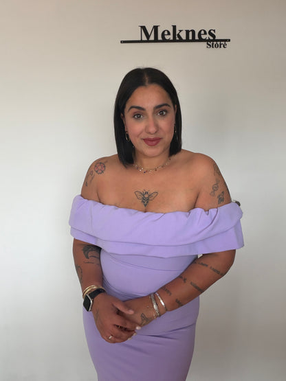 Vista lateral de vestido lila ajustado mostrando la caída del volante en los hombros